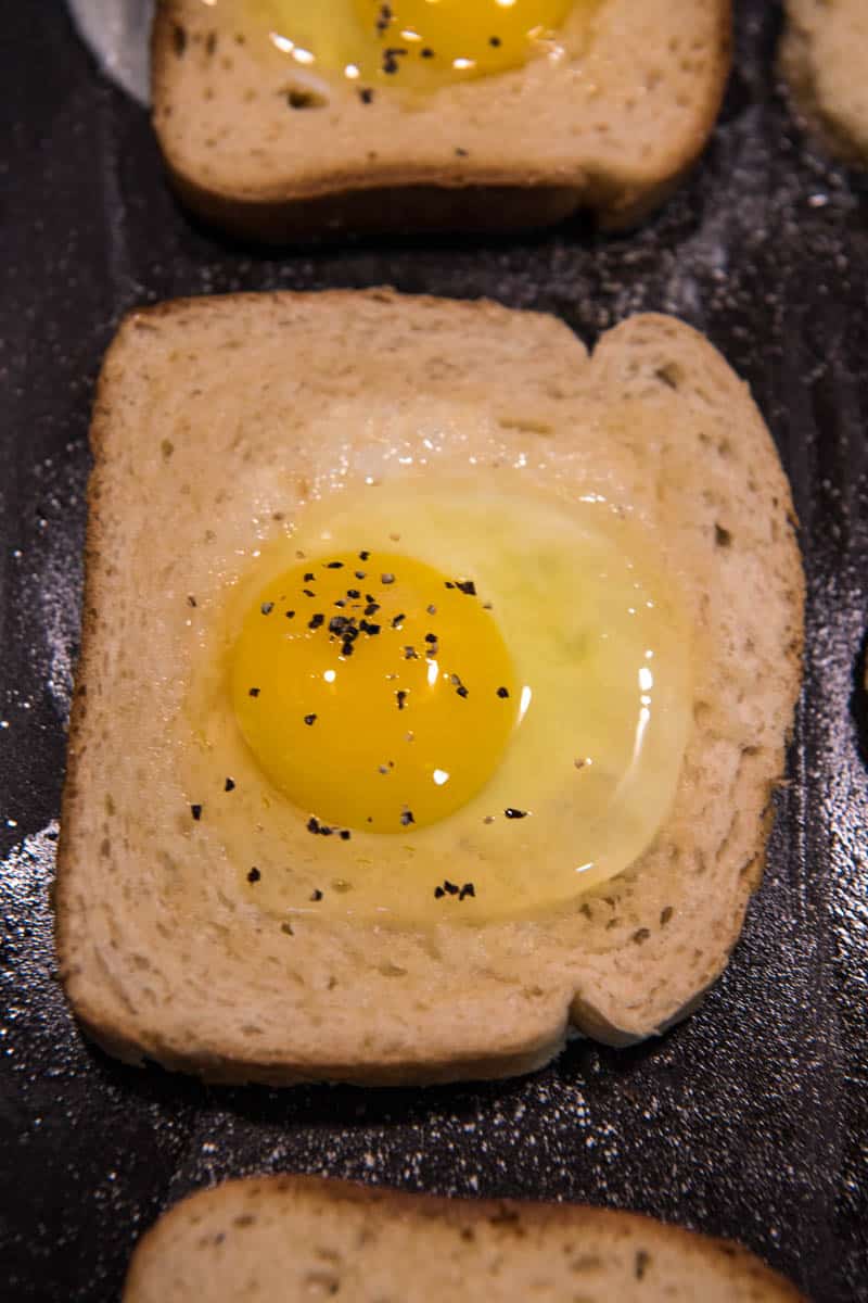 salt and pepper added to egg in a nest
