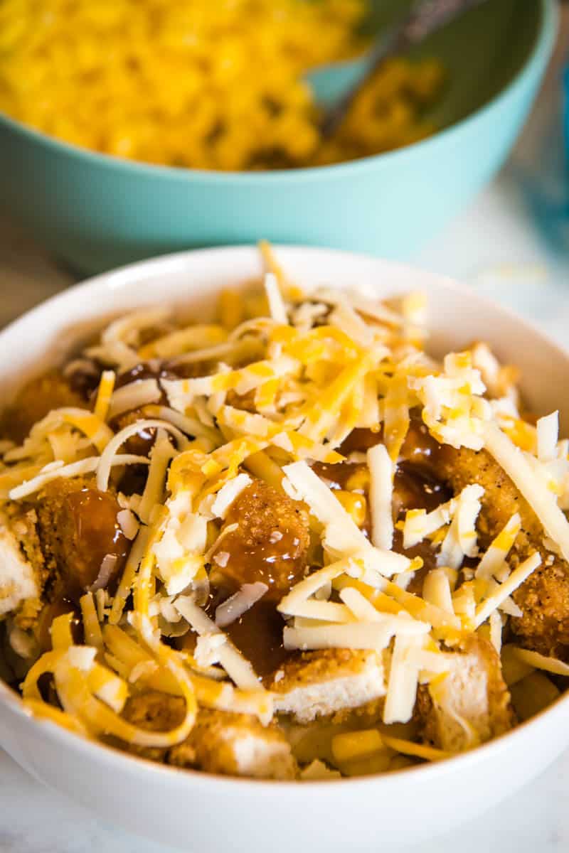 shredded cheese on top of homemade KFC bowl in white serving bowl