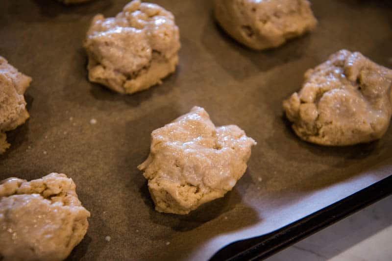 Bisquick scones with buttermilk brushed on top on parchment paper lined baking sheet
