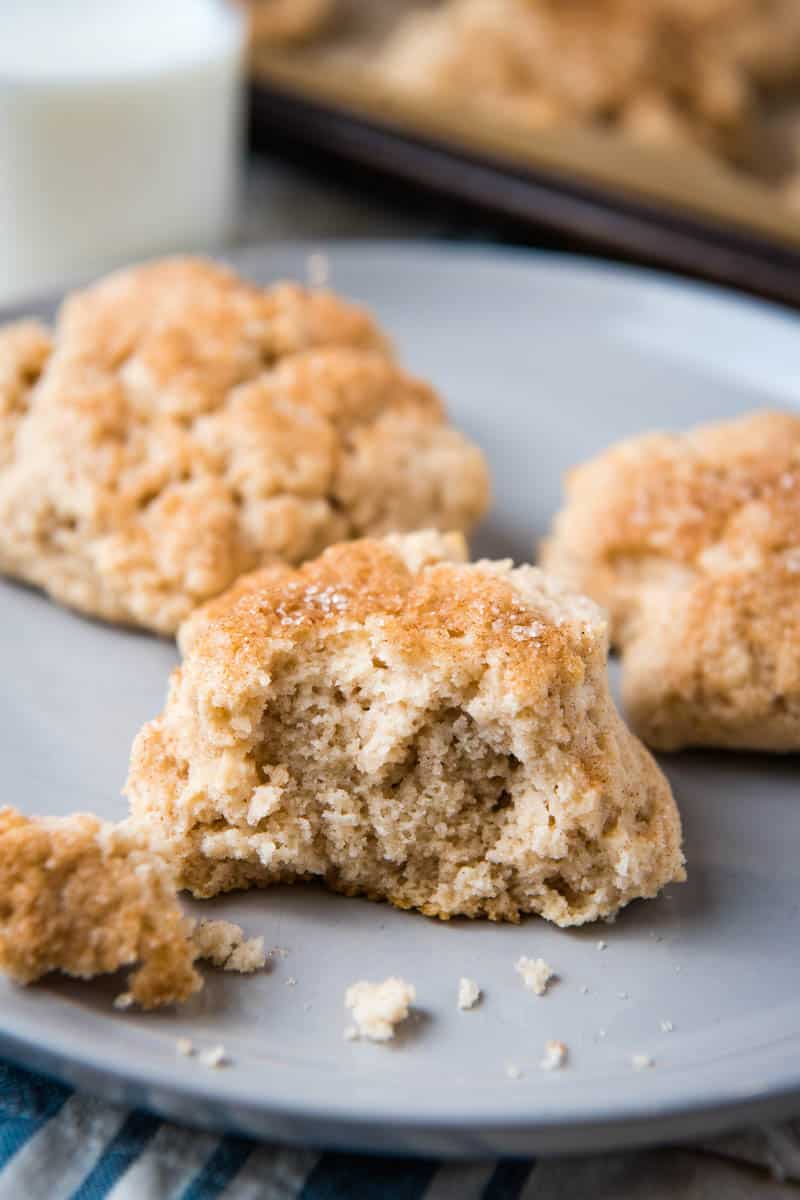 Bisquick drop scone sprinkled with cinnamon sugar and sliced in half on gray plate with other scones