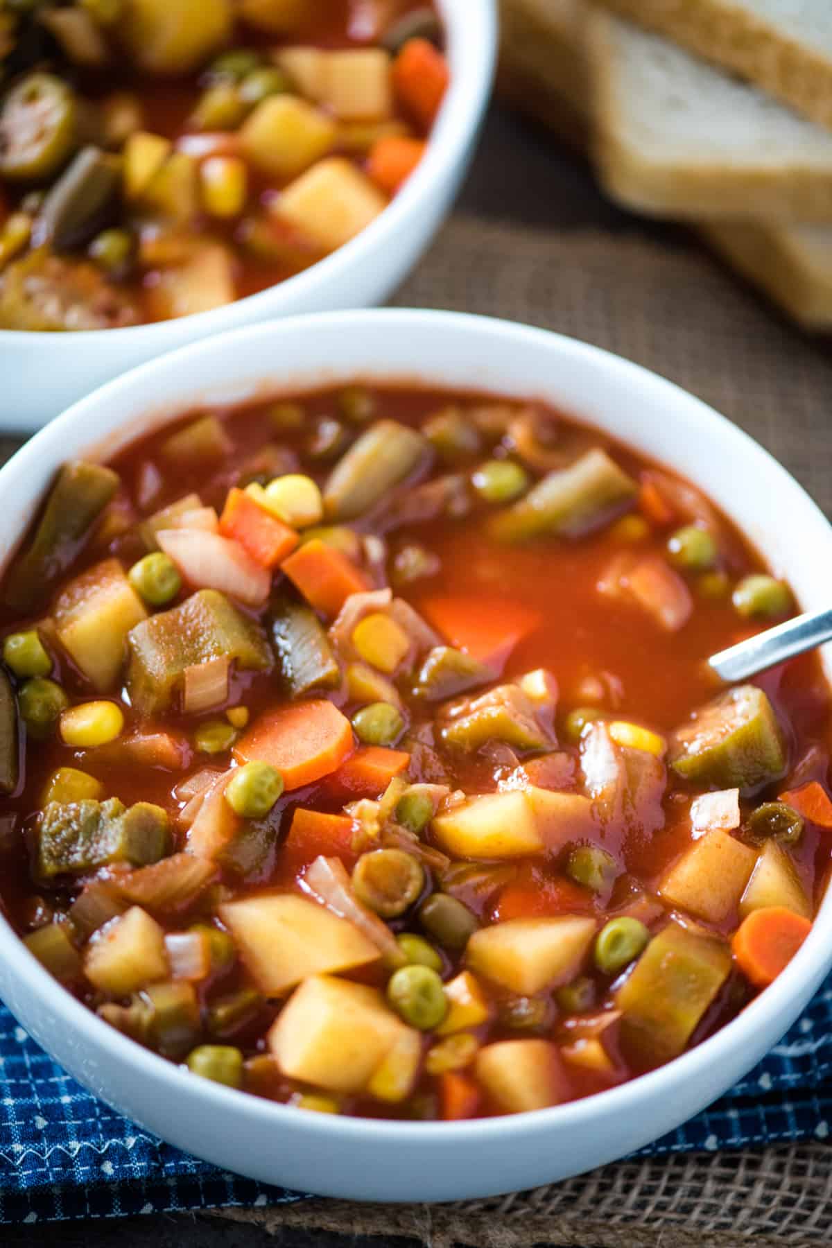 easy V8 vegetable soup in white soup bowl with spoon