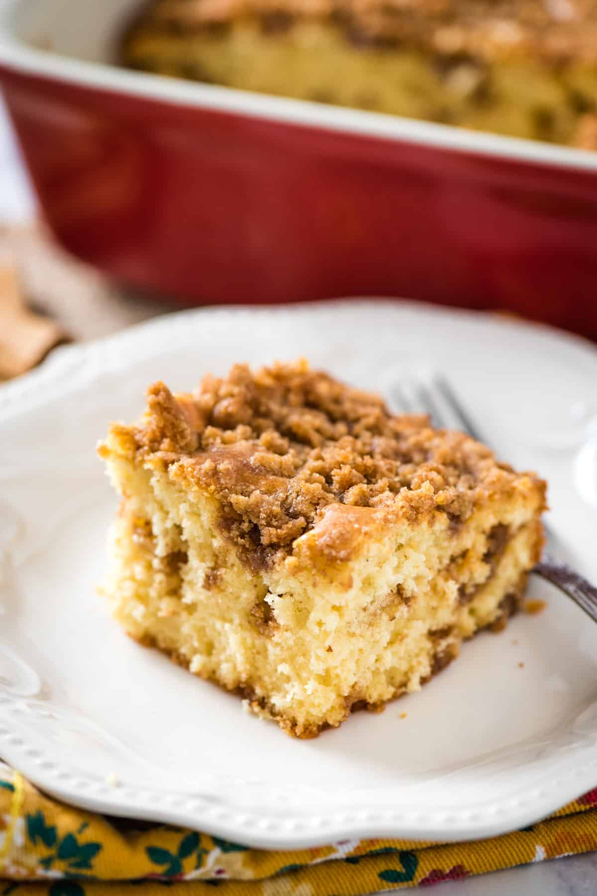 slice of brown sugar coffee cake on white plate with fork