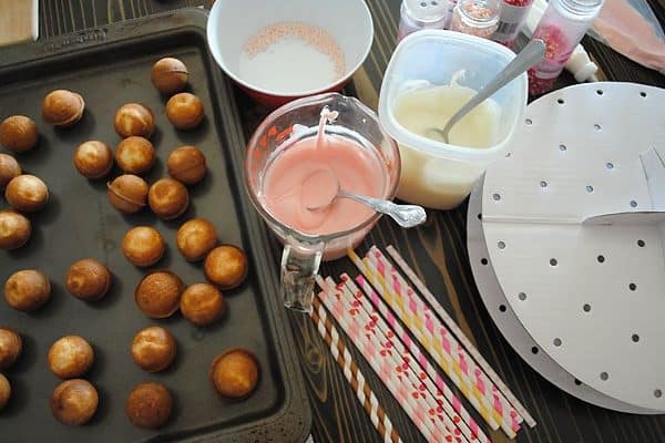 supplies and cake balls for making Valentine's Day cake pops on wood table