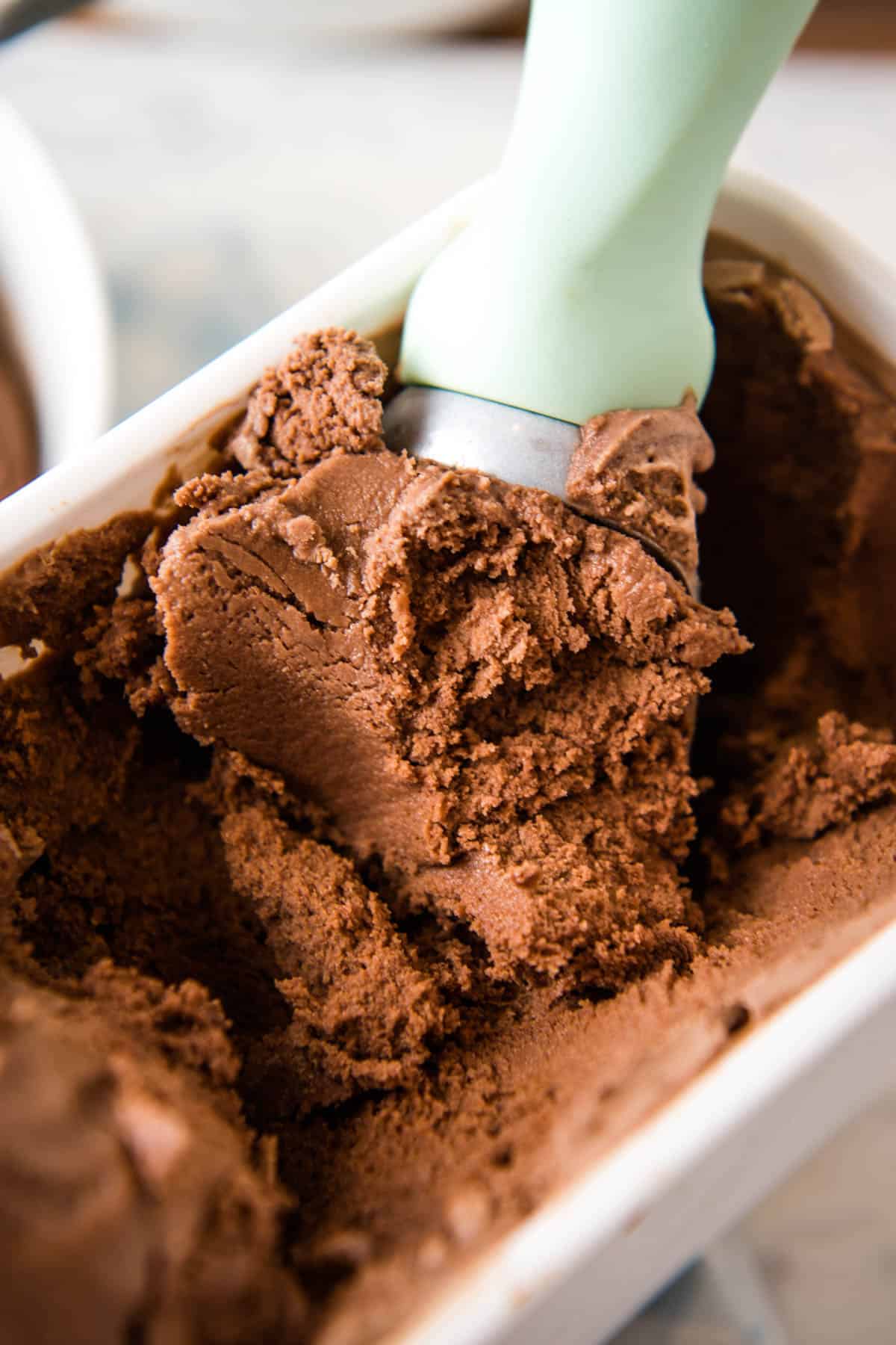 mint green ice cream scoop scooping chocolate ice cream no eggs from white ice cream container