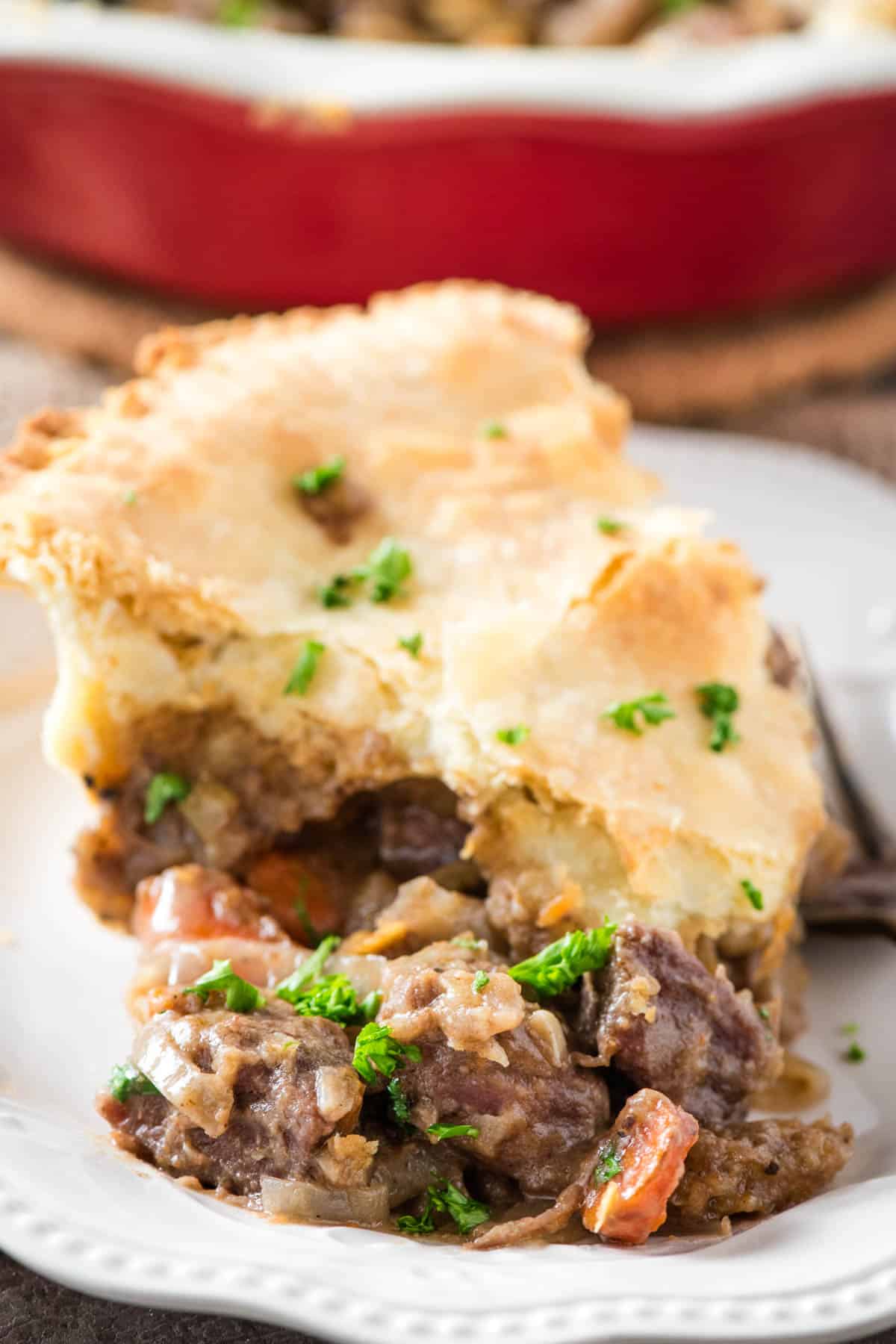 sliced wedge of beef pot pie on a small white saucer