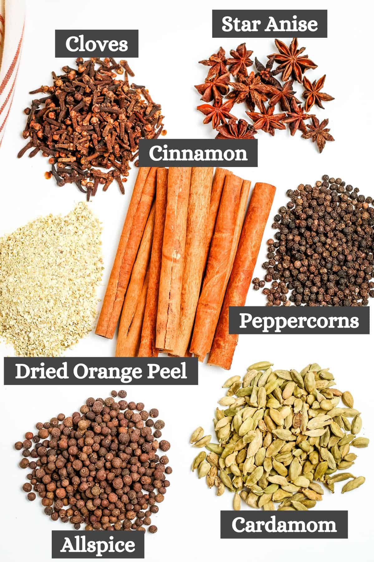 mulling spice recipe ingredients laid out on a white countertop ready to make recipe for mulling spices for cider