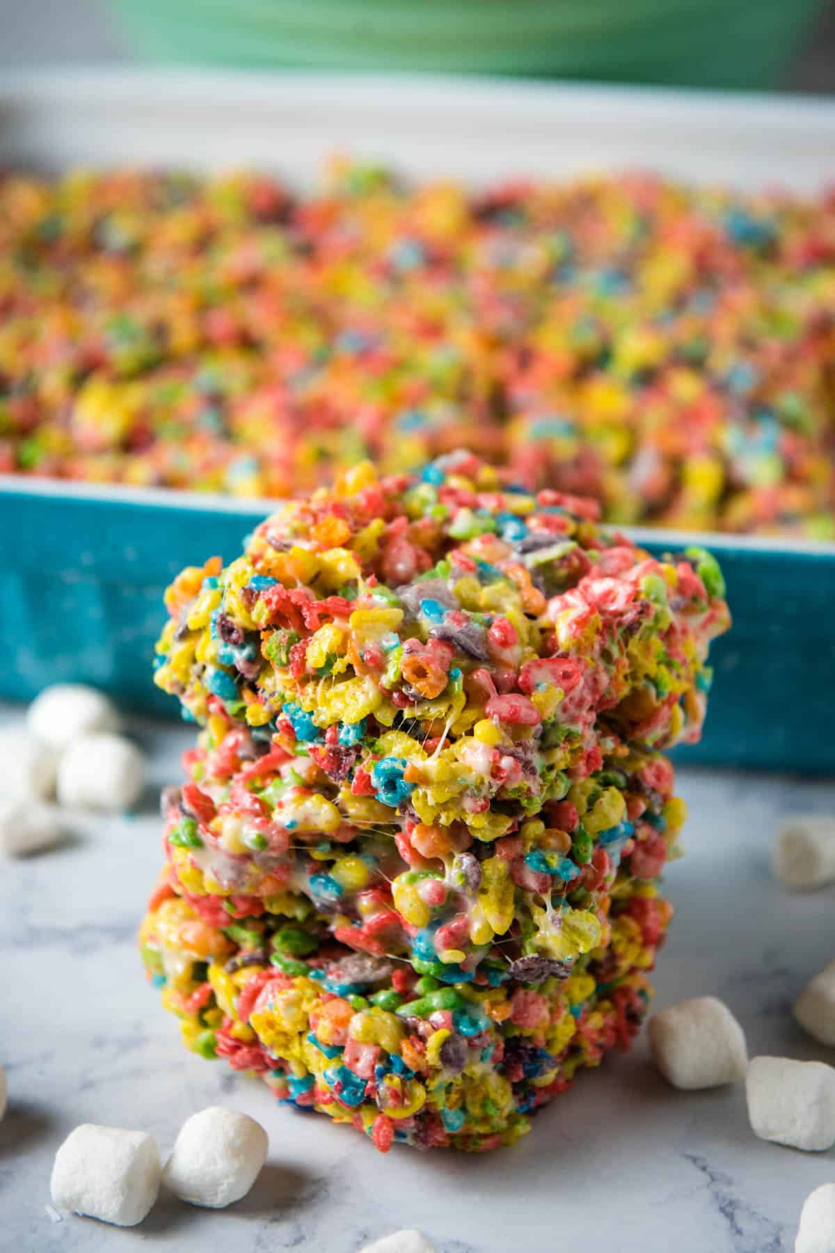 stack of fruity pebble treats on a marbled white countertop