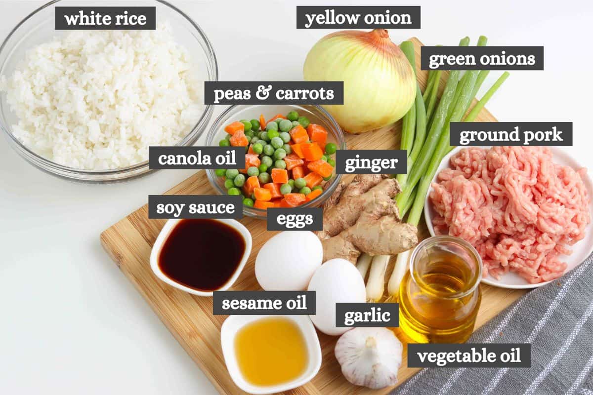 pork fried rice ingredients lined out on a wooden cutting board