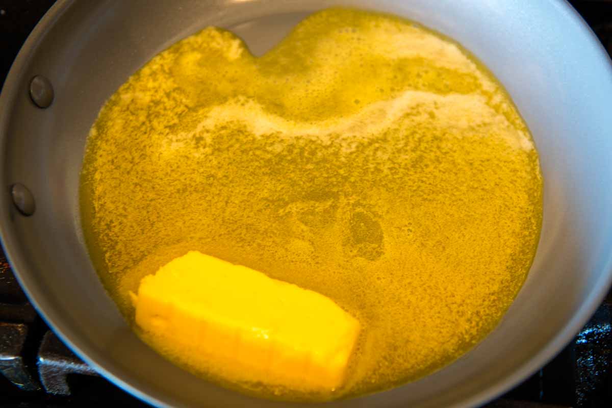 melted butter in a large gray skillet on the stovetop