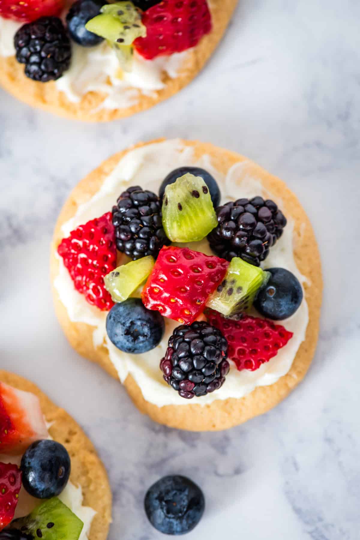 mini fruit pizzas on a marbled white countertop